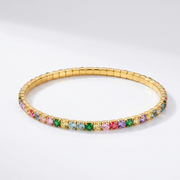 Gold bracelet with multicolored gemstones on a white background