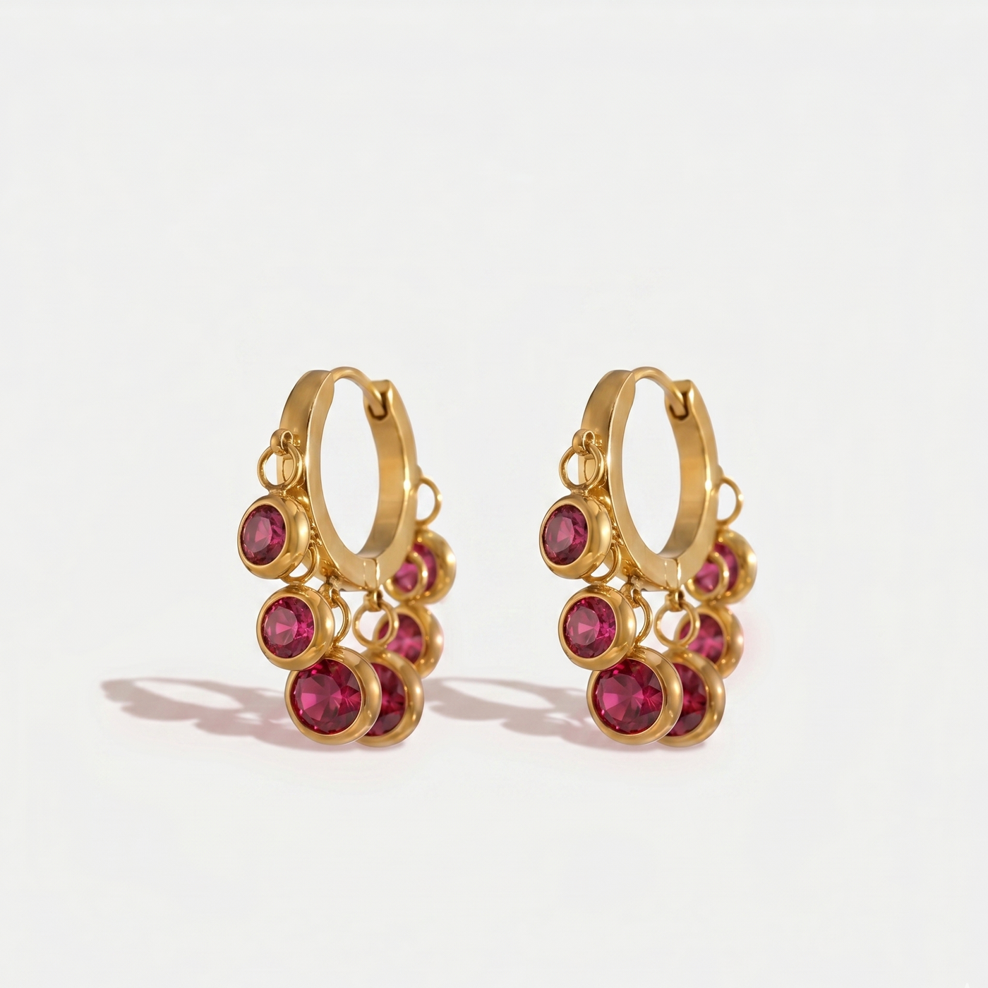 Ruby Rose Set gold huggie earrings with dangling ruby pink stones.