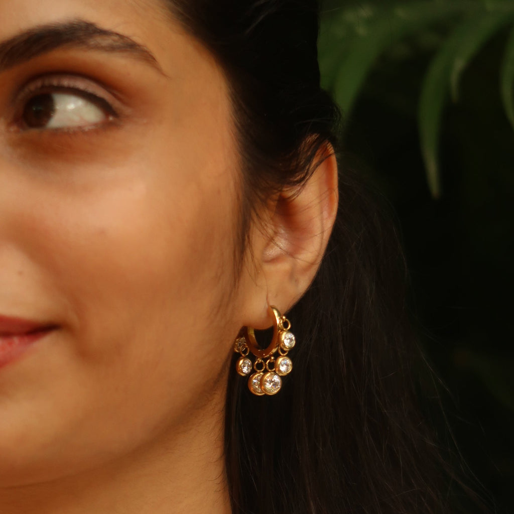 Royal Exotic Huggies white – women wearing gold huggie hoop earrings lifestyle shot India
