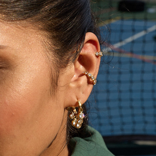 Royal Exotic Huggies white stone huggie earrings – model wearing gold hoop earrings India
